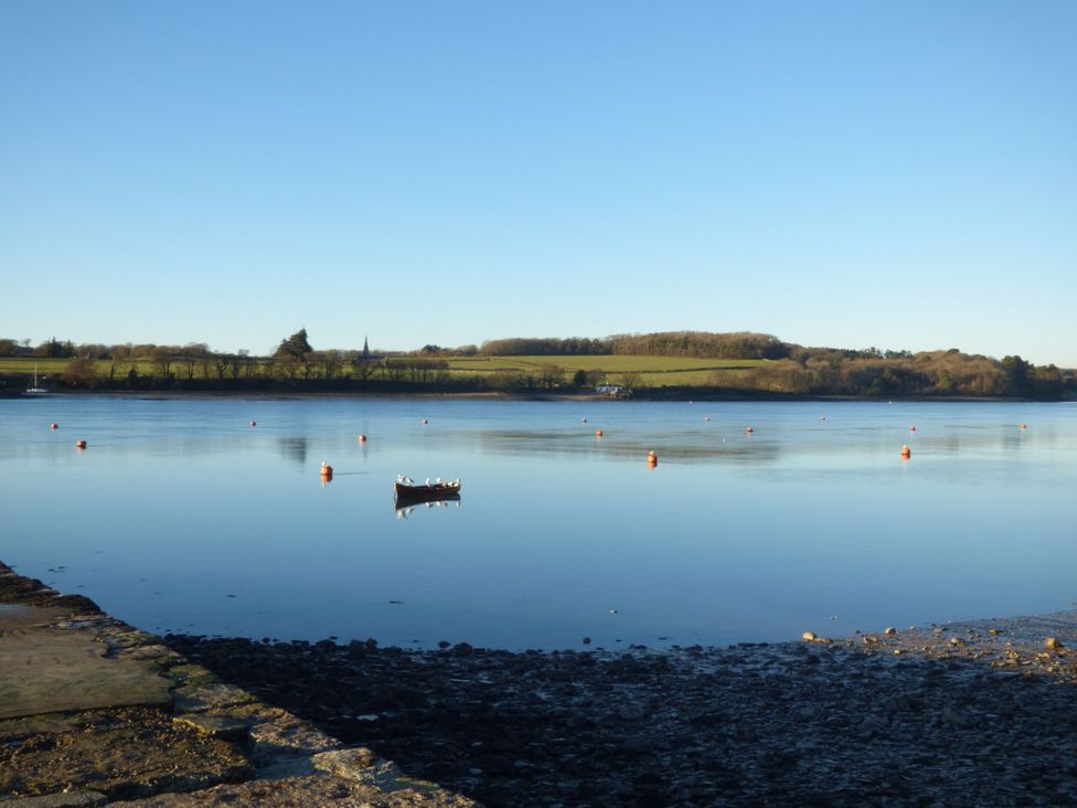 A boat on the water with buoys and trees at Glasfryn in Llandwrog