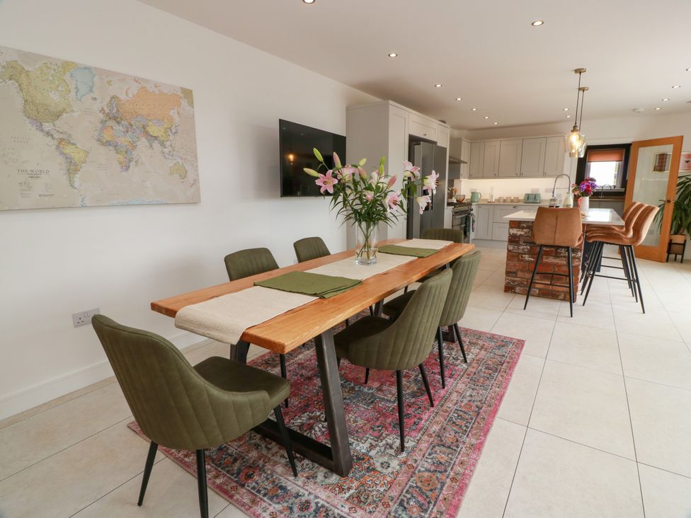 A dining room with a wooden table and chairs at Balcarry Barn Glenluce