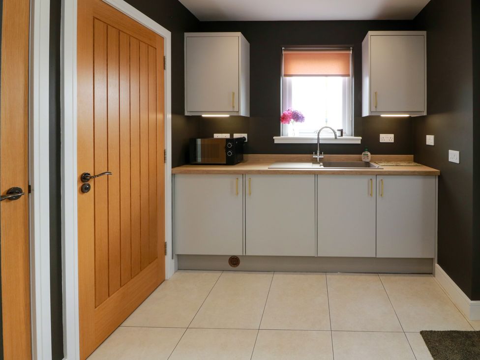 A kitchen with cabinets and a sink at Balcarry Barn in Glenluce