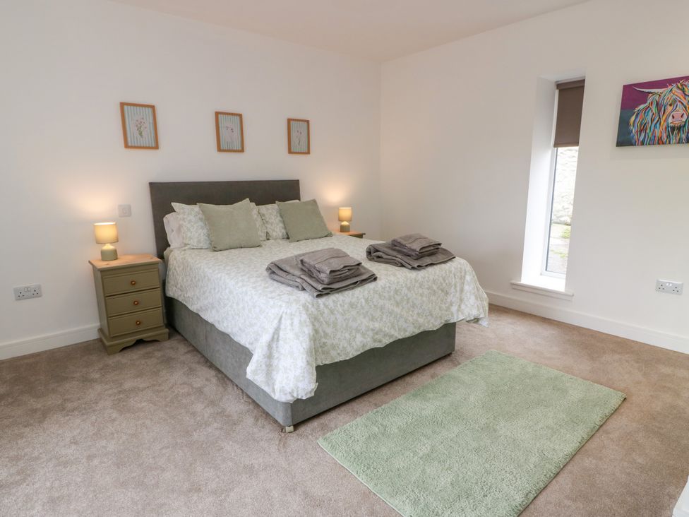 A bedroom with a bed and nightstand at Balcarry Barn in Glenluce
