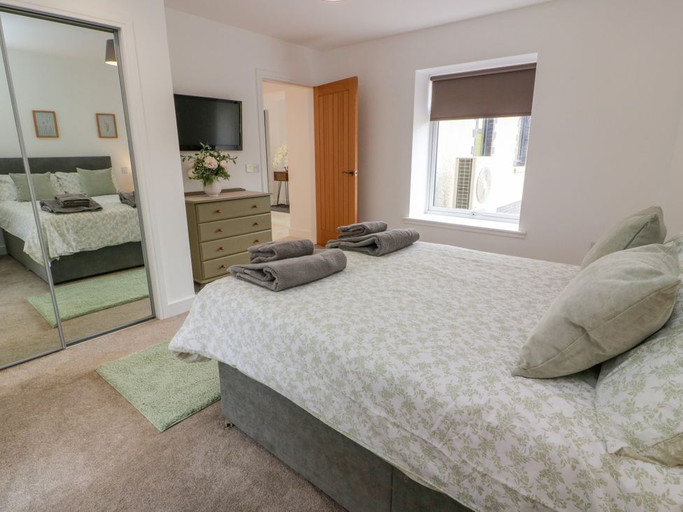 A bedroom with a bed and towels on top at Balcarry Barn in Glenluce