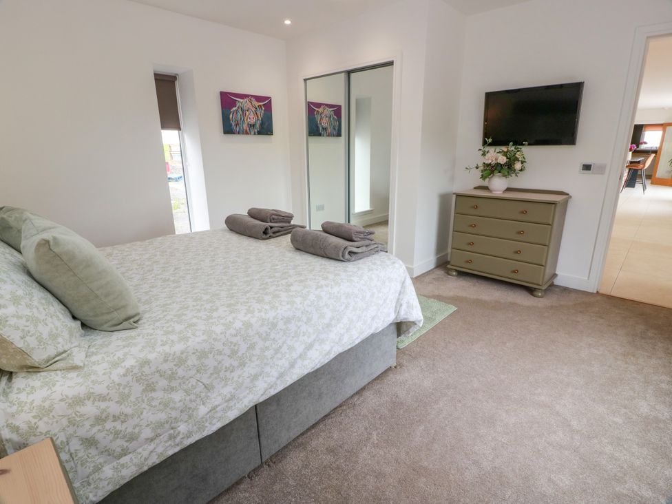 A bedroom with a bed and television at Balcarry Barn Glenluce