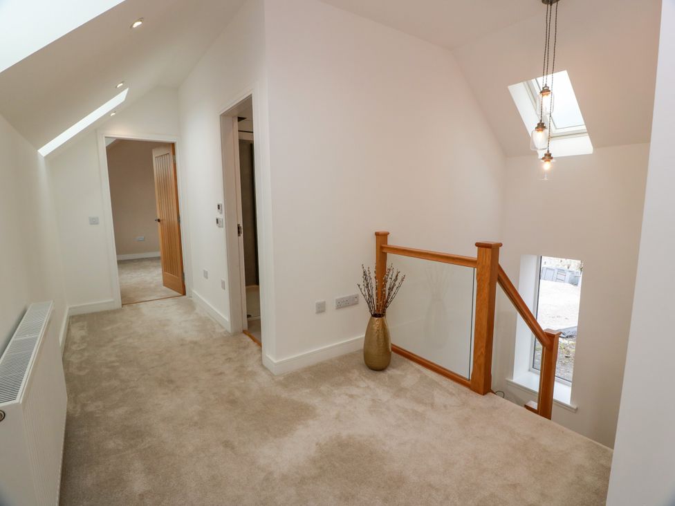 A hallway with a staircase and a vase at Balcarry Barn Glenluce