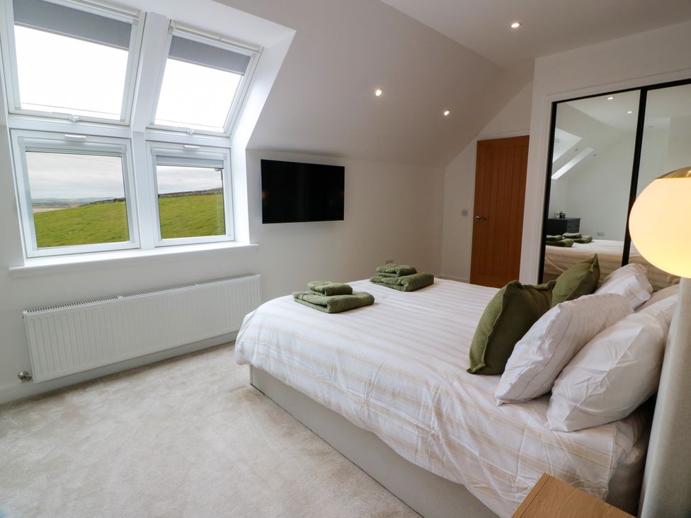 A bedroom with a bed and towels on the bed at Balcarry Barn Glenluce