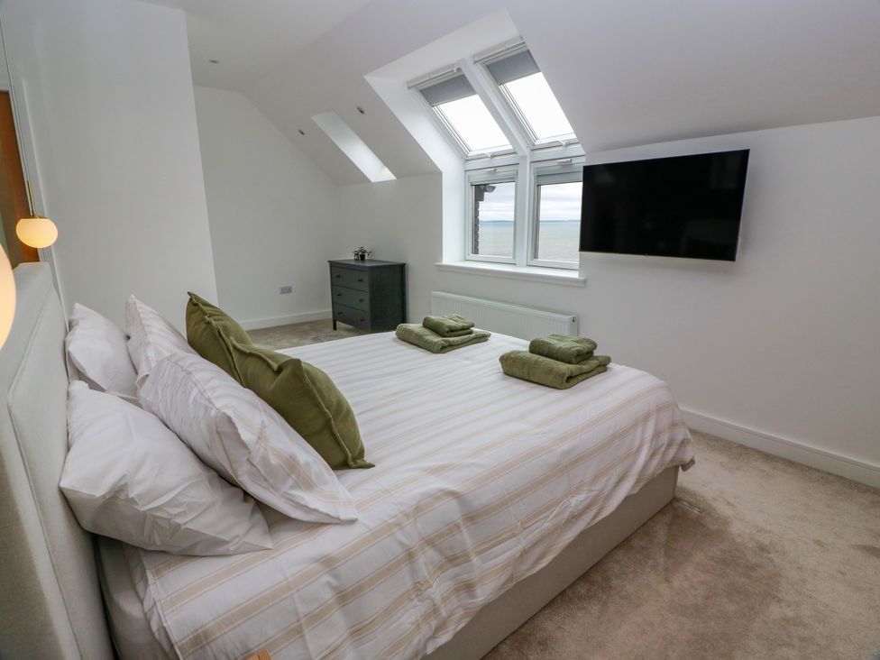 A bedroom with a bed and television at Balcarry Barn in Glenluce