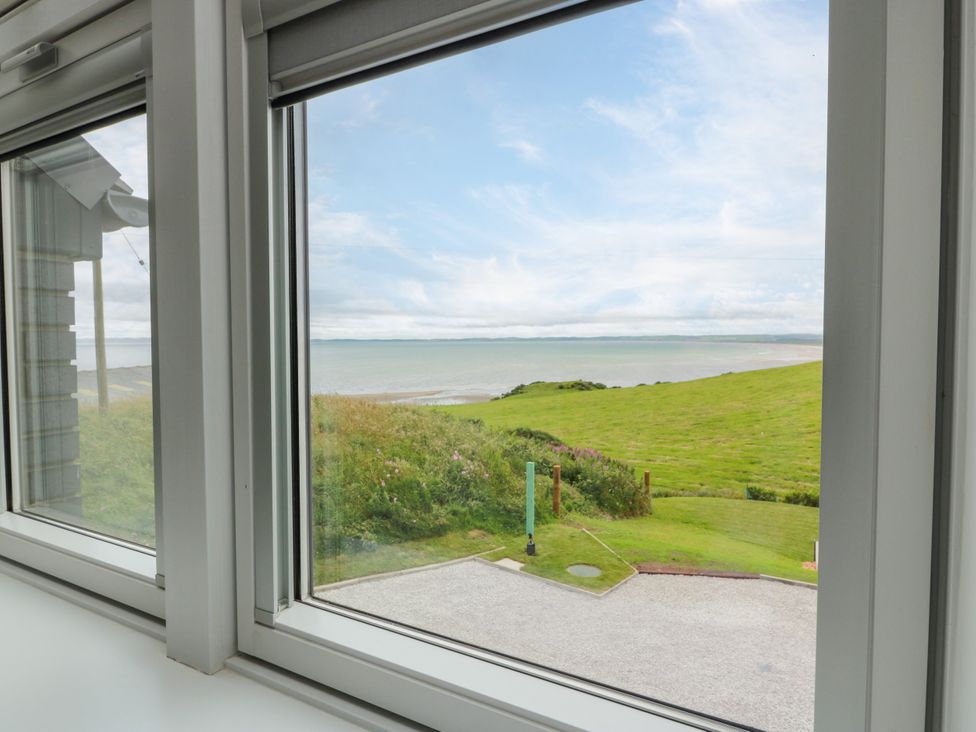 A window view showing the ocean and grass at Balcarry Barn Glenluce