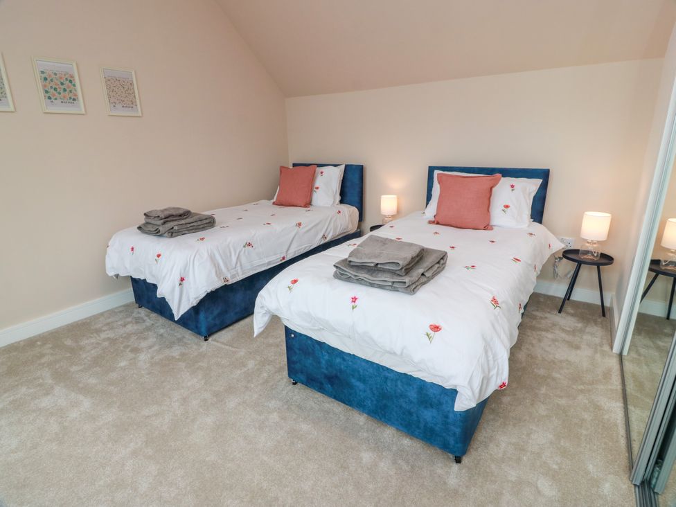 A bedroom with two single beds and nightstands at Balcarry Barn Glenluce
