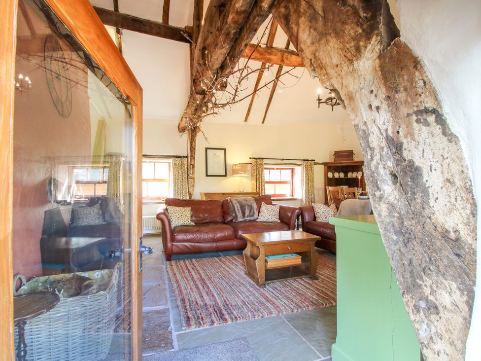 A living room with sofas and a table at The Long House near Trefonen