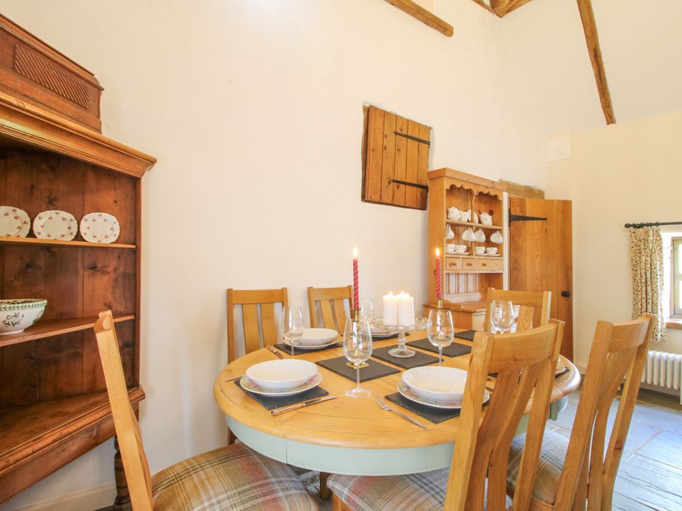 A dining room with a table set for a meal at The Long House near Trefonen