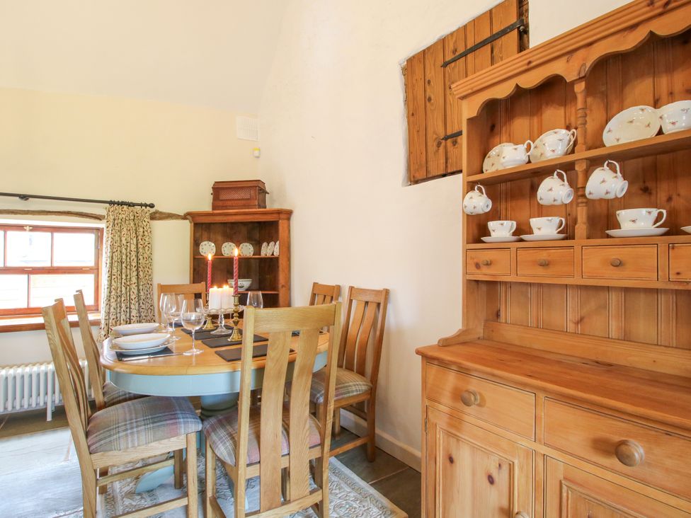 A dining room with a table set for meals at The Long House near Trefonen