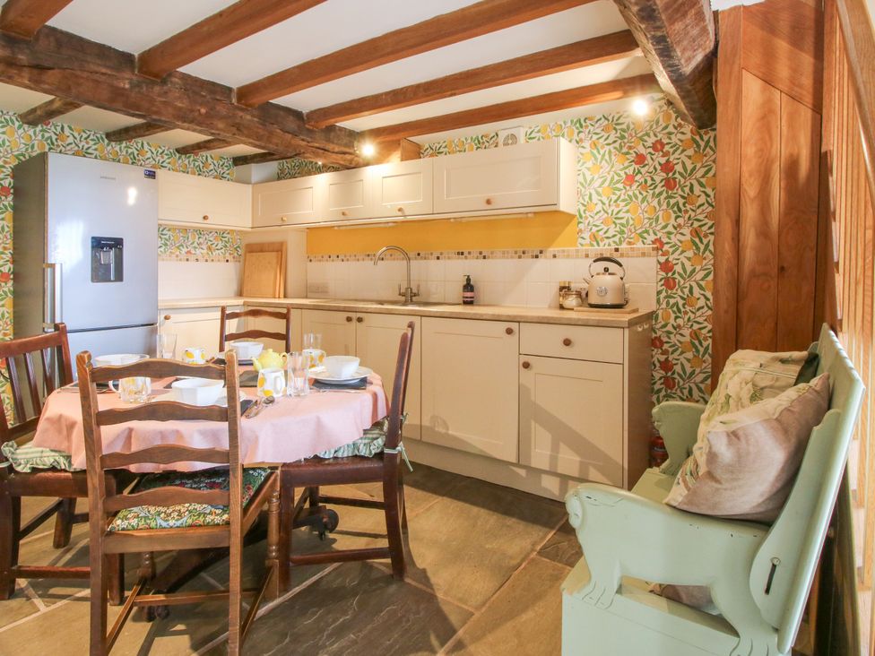 A kitchen with a table and chairs at The Long House Near Trefonen