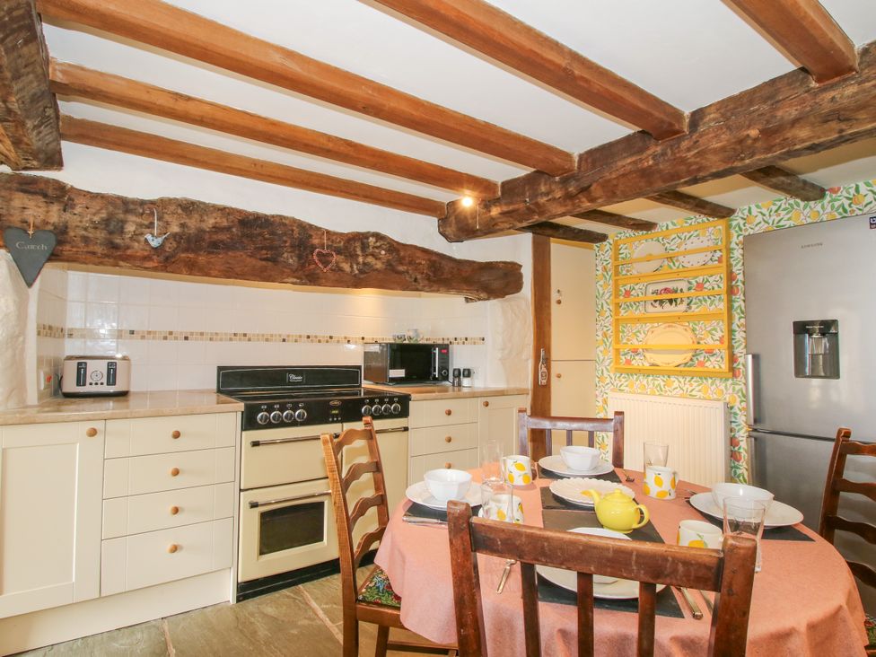 A kitchen with a table set for dining at The Long House Near Trefonen