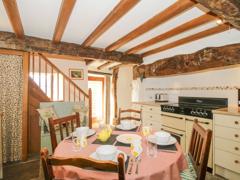 A dining room with a table set for meals at The Long House near Trefonen