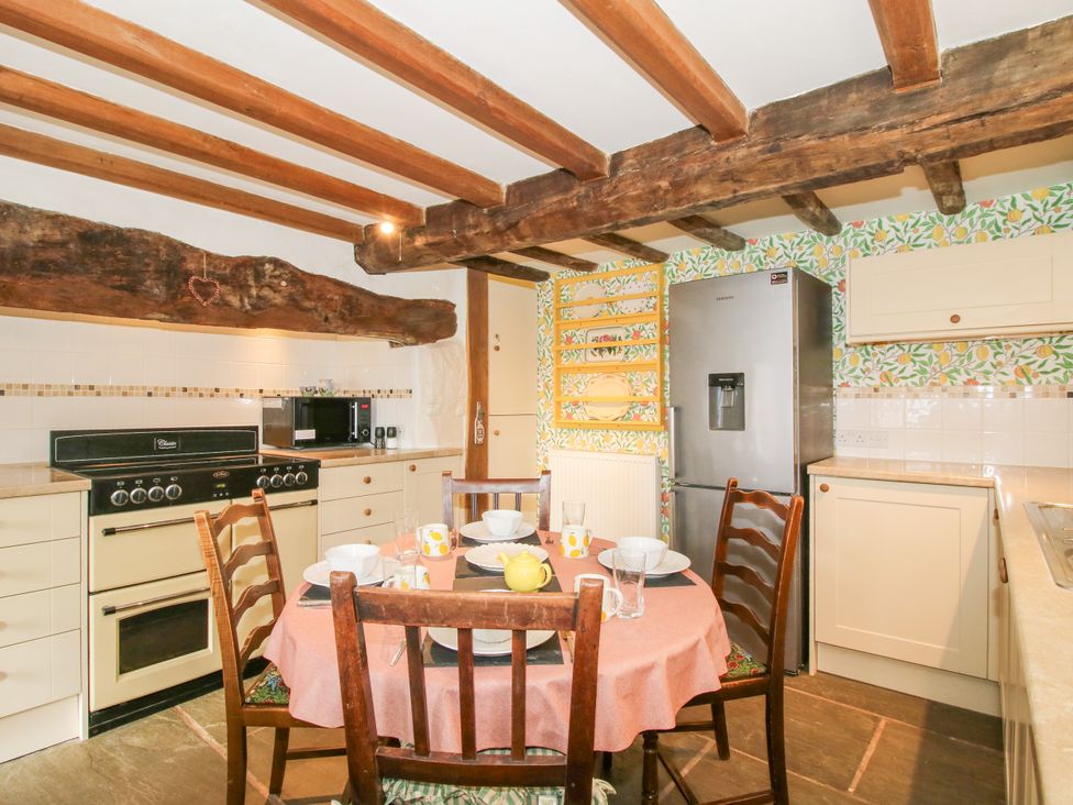 A kitchen with dining table and chairs at The Long House near Trefonen