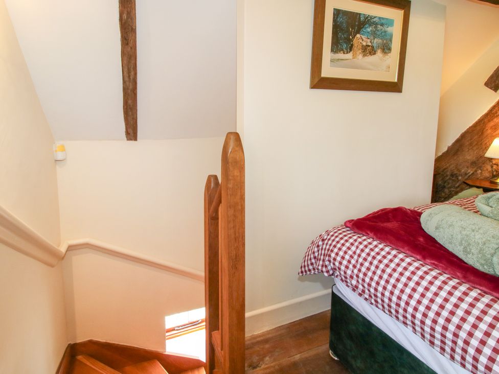 A staircase leading up next to a bed at The Long House Near Trefonen
