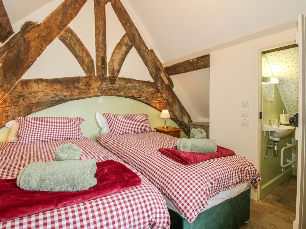 A bedroom with two beds and a bathroom at The Long House near Trefonen
