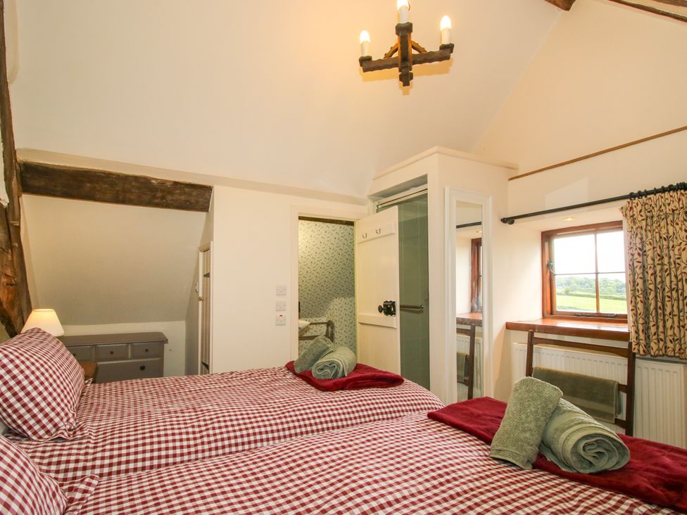 A bedroom with two beds and a window at The Long House Near Trefonen