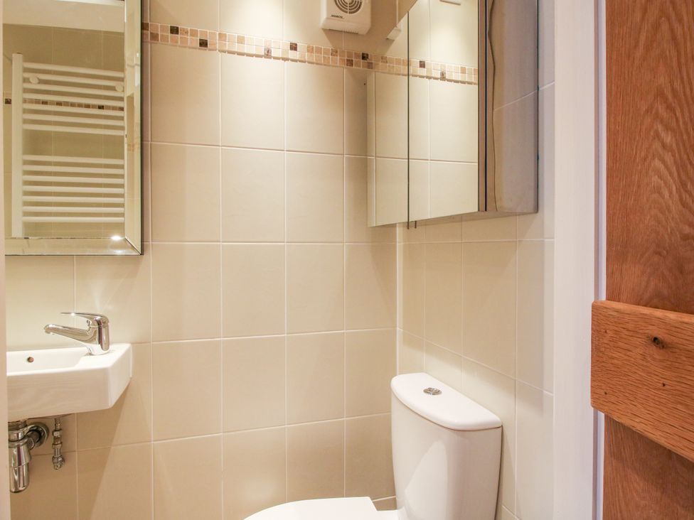 A bathroom with a toilet and sink at The Long House Near Trefonen