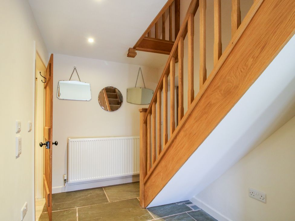 A hallway with stairs and mirrors at The Long House near Trefonen