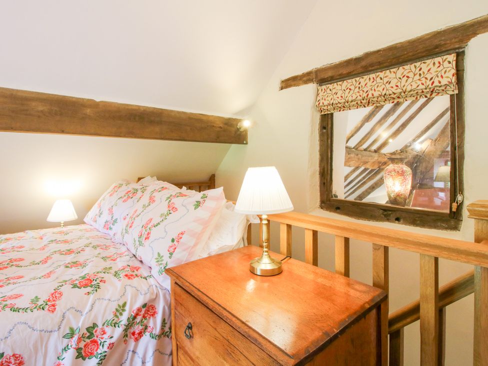 A bedroom with a bed and lamp at The Long House, Near Trefonen