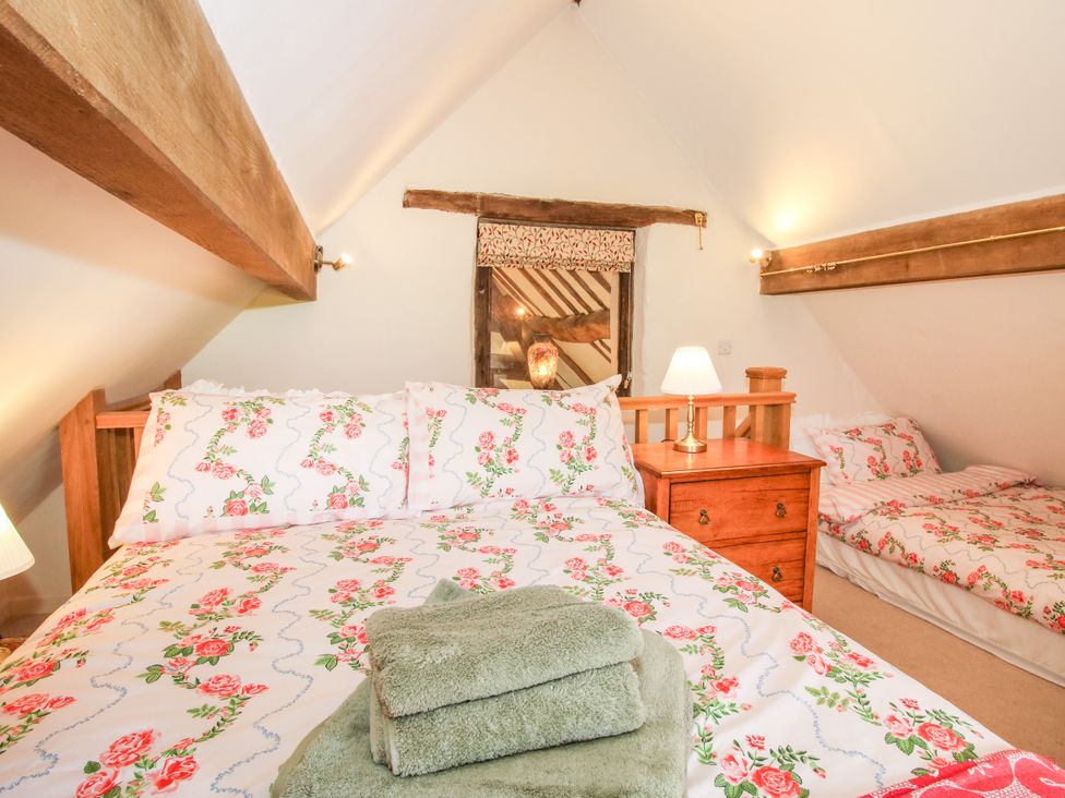 A bedroom with a double bed and a single bed at The Long House near Trefonen