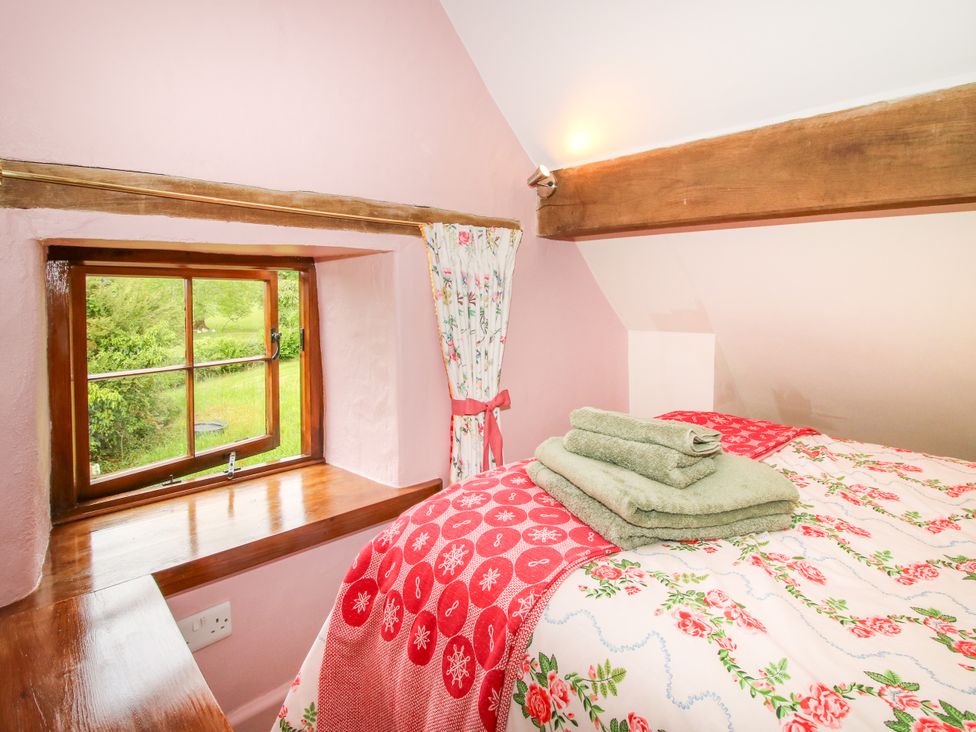A bedroom with a bed and towels at The Long House Near Trefonen