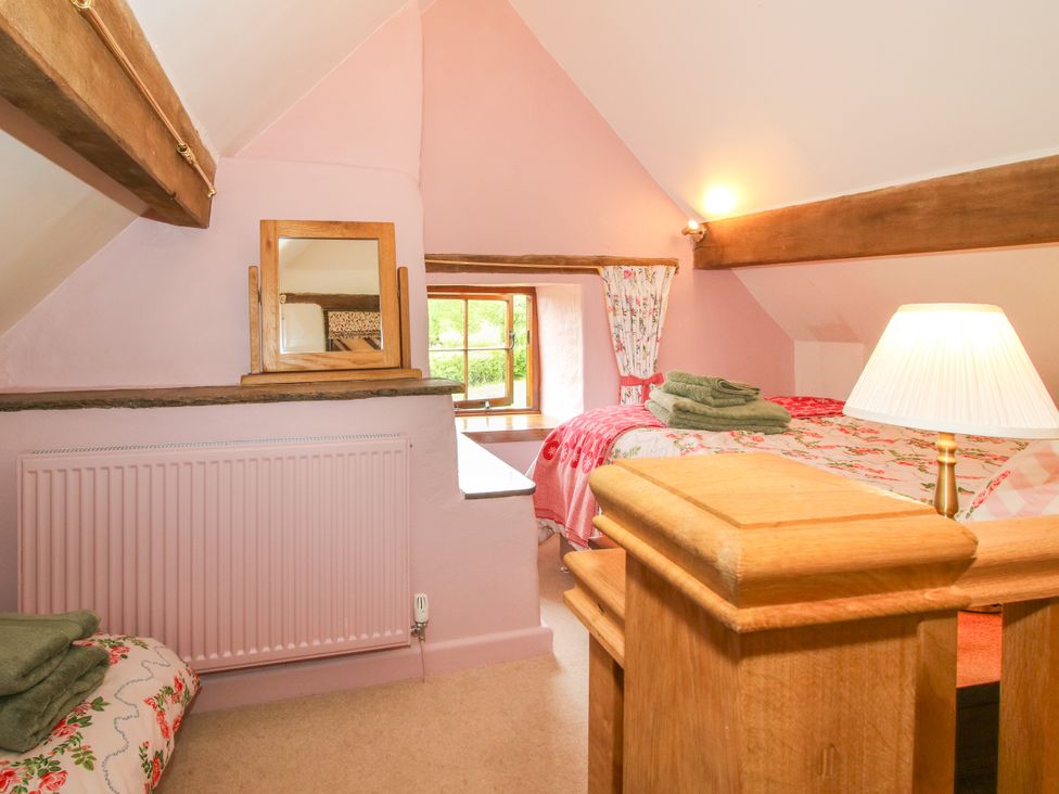 A bedroom with a bed and window at The Long House Near Trefonen