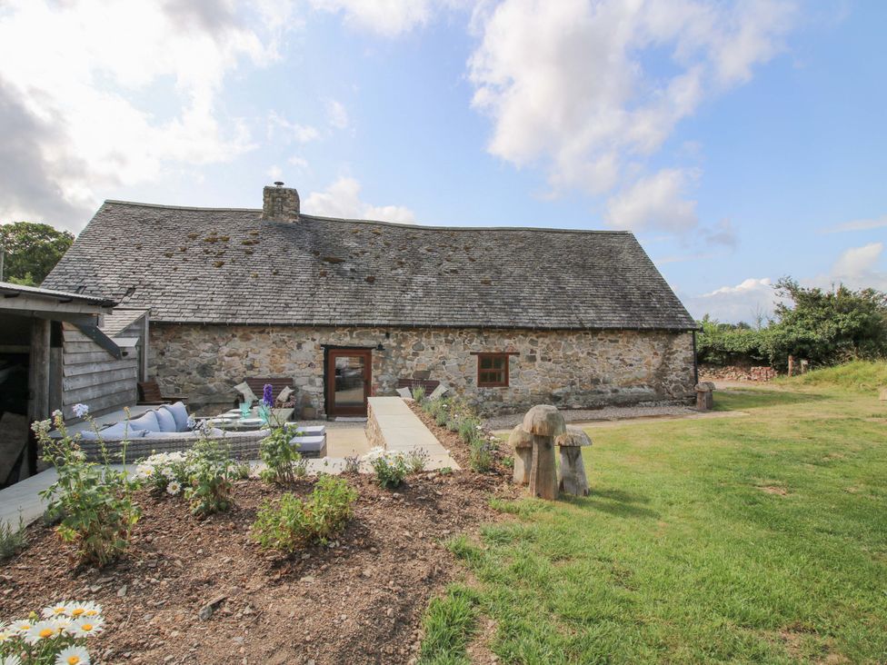 A barn with pathway and outdoor seating at The Long House Near Trefonen