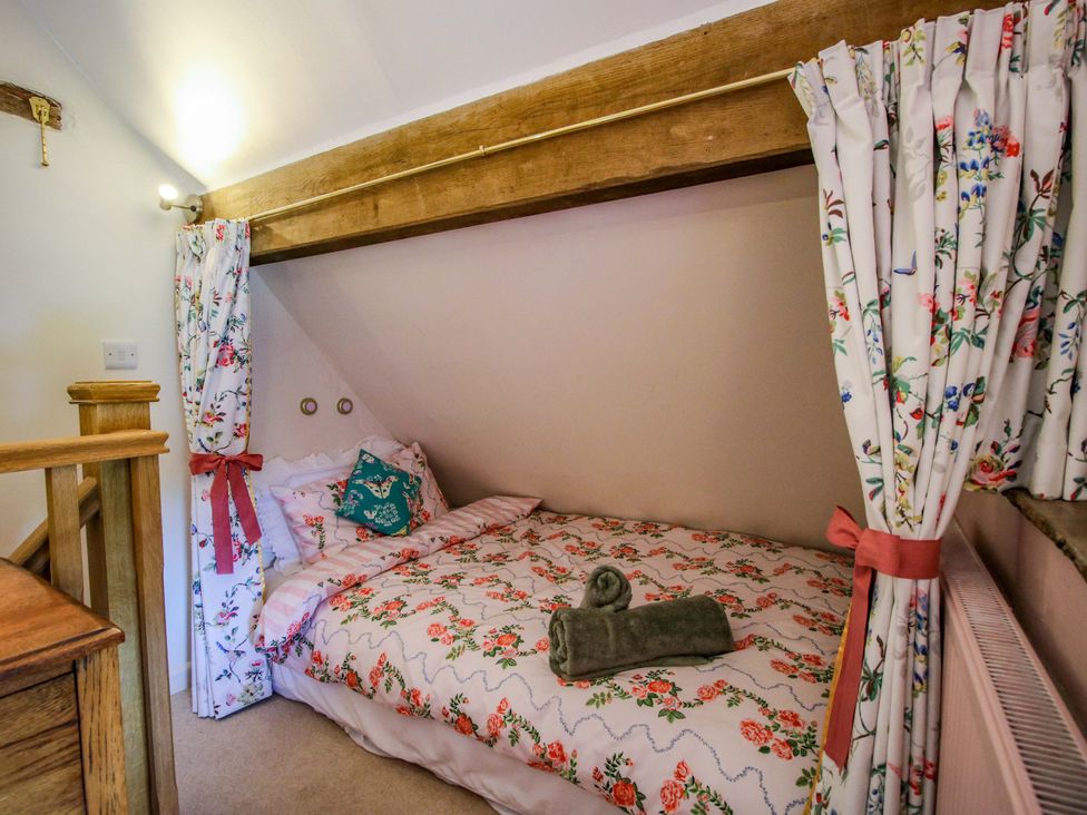 A bedroom with a bed and curtains at The Long House Near Trefonen