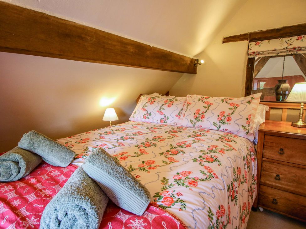 A bedroom with a bed and dresser at The Long House near Trefonen