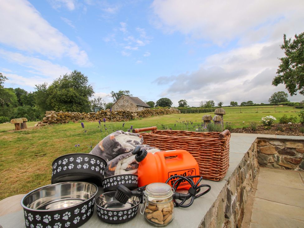 Dog bowls and treats on a table in an outdoor area at The Long House near Trefonen