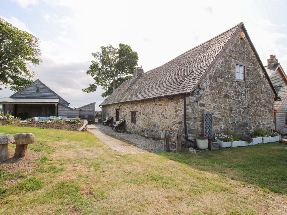 A stone house with a pathway and garden at The Long House near Trefonen