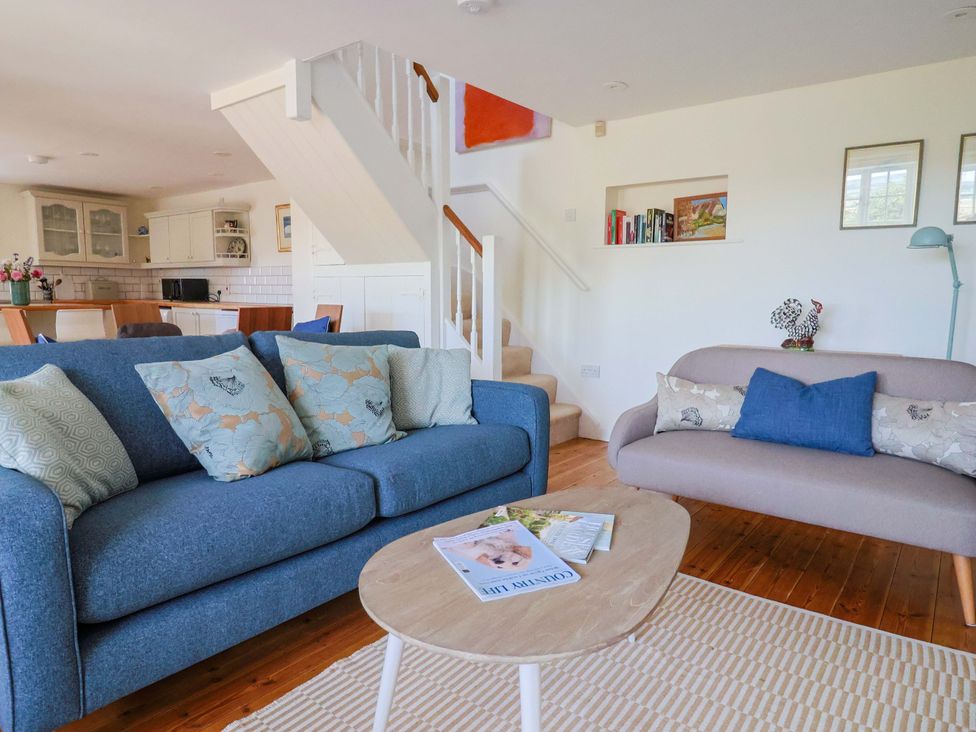 A living room with a sofa and coffee table at Tithe Barn Cottage in Litton Cheney near Burton Bradstock