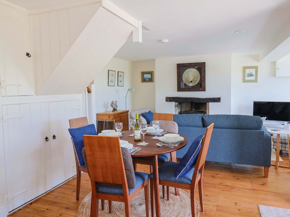 A dining room with a table and chairs at Tithe Barn Cottage Litton Cheney near Burton Bradstock