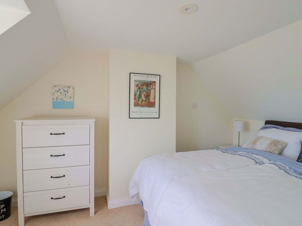 A bedroom with a bed and a chest of drawers at Tithe Barn Cottage in Litton Cheney near Burton Bradstock