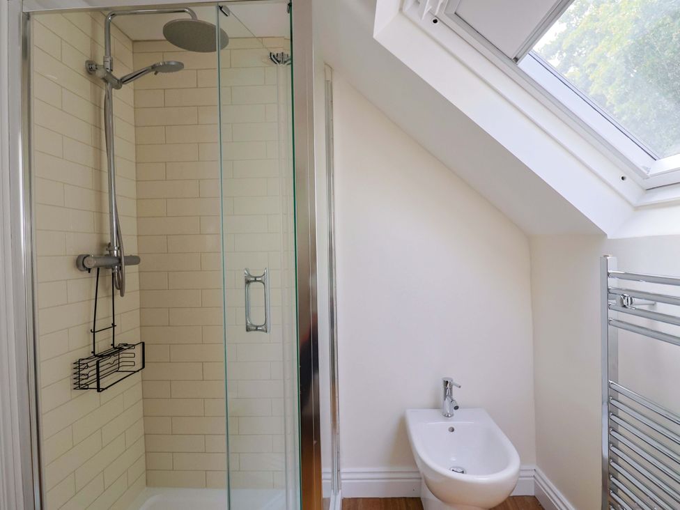 A bathroom with a shower and bidet at Tithe Barn Cottage Litton Cheney near Burton Bradstock