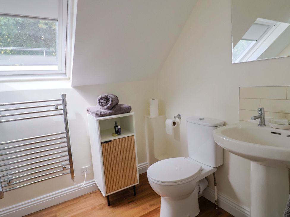 A bathroom with a toilet and sink at Tithe Barn Cottage in Litton Cheney near Burton Bradstock