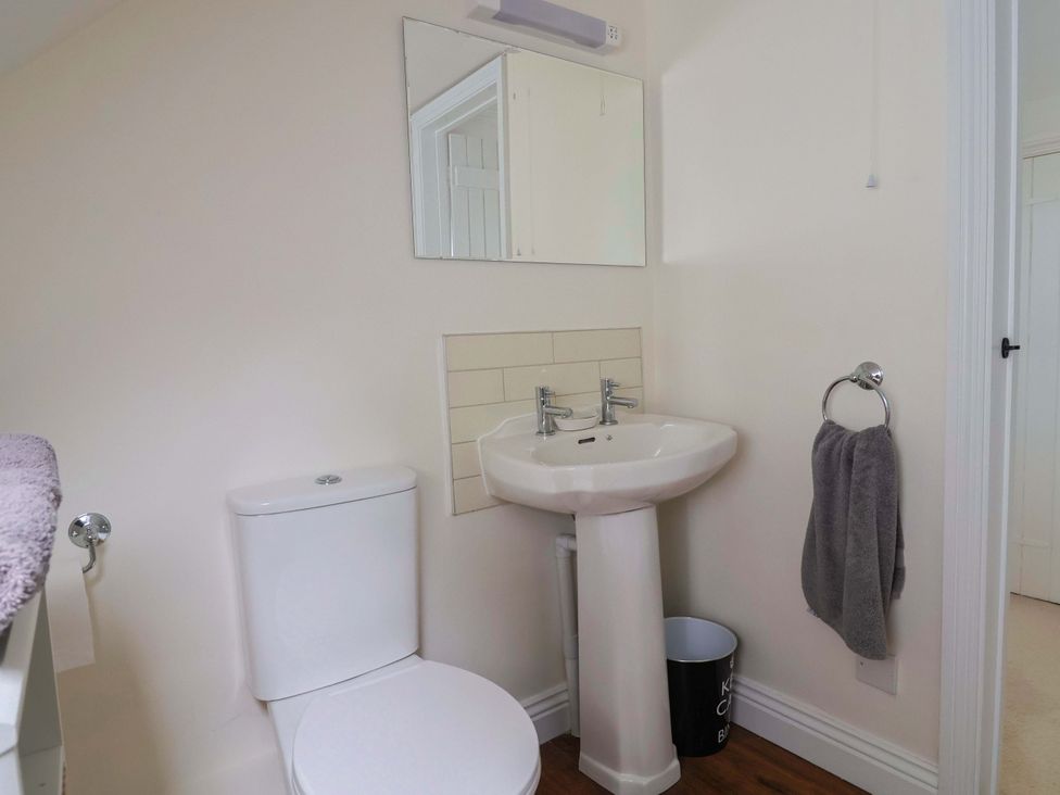 A bathroom with a toilet and sink at Tithe Barn Cottage Litton Cheney near Burton Bradstock