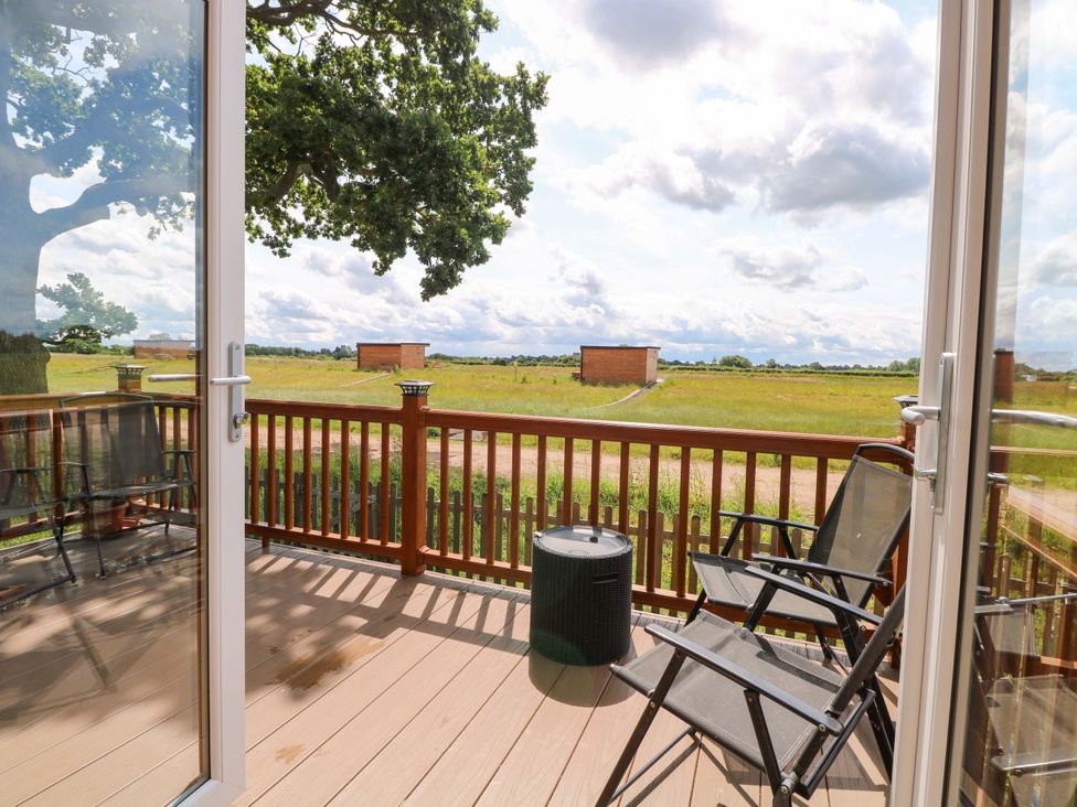 An outdoor area with chairs and a view at Oak Tree Holiday Lodge in Stonham Aspal