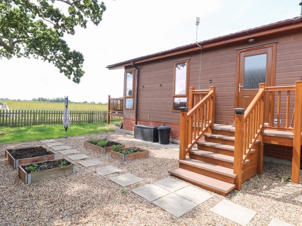 An outdoor area with steps and garden beds at Oak Tree Holiday Lodge in Stonham Aspal