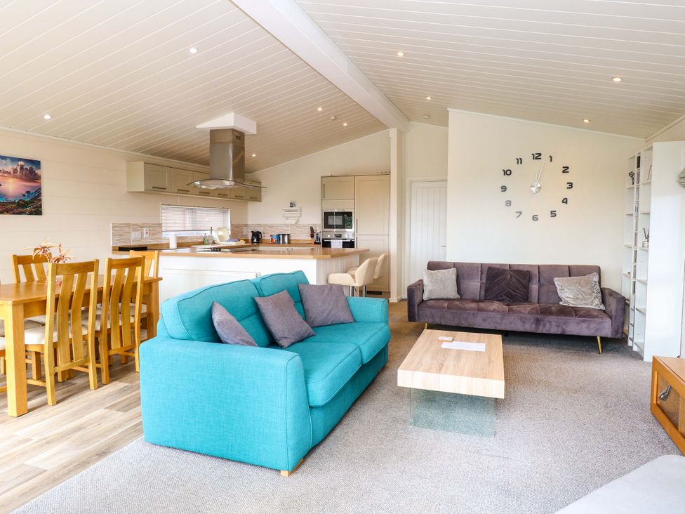 A living room with a dining area and kitchen at Oak Tree Holiday Lodge in Stonham Aspal
