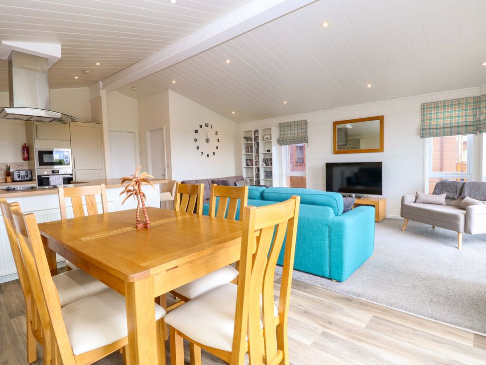 A living room with a dining area and kitchen at Oak Tree Holiday Lodge in Stonham Aspal