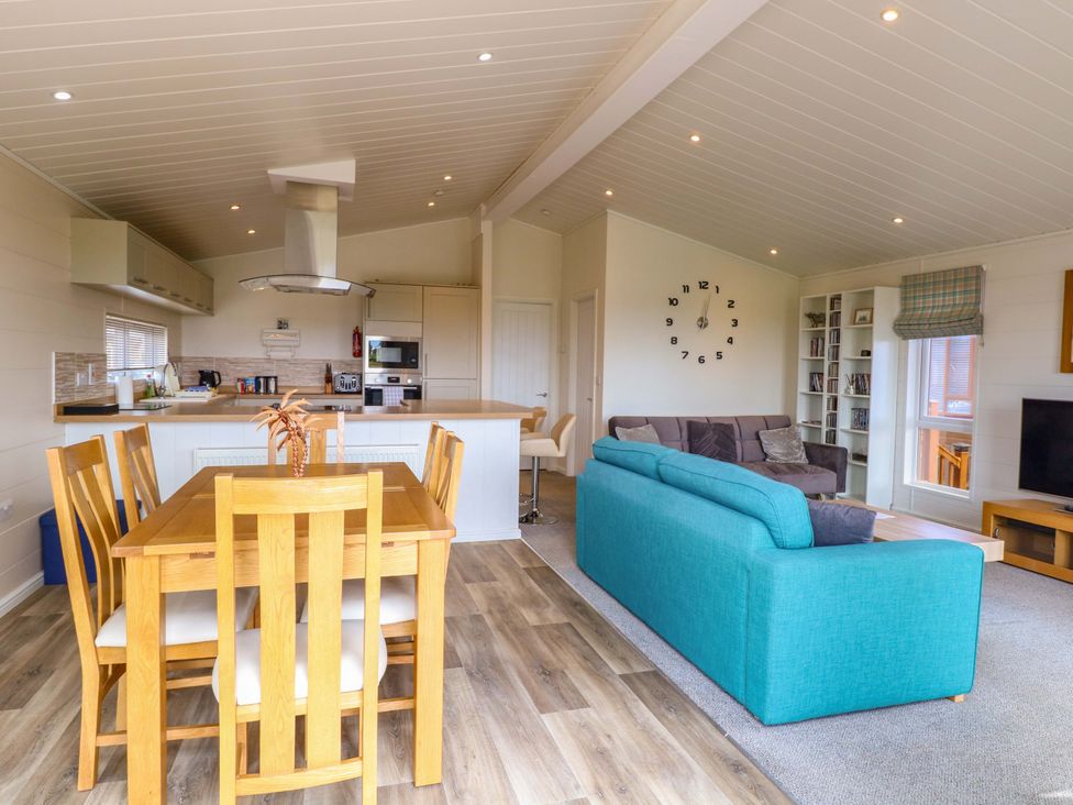 A living room with kitchen and dining area at Oak Tree Holiday Lodge Stonham Aspal