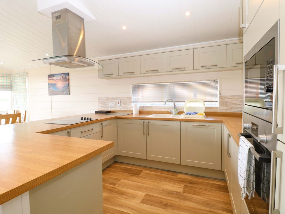 A kitchen with cabinets and a sink at Oak Tree Holiday Lodge Stonham Aspal