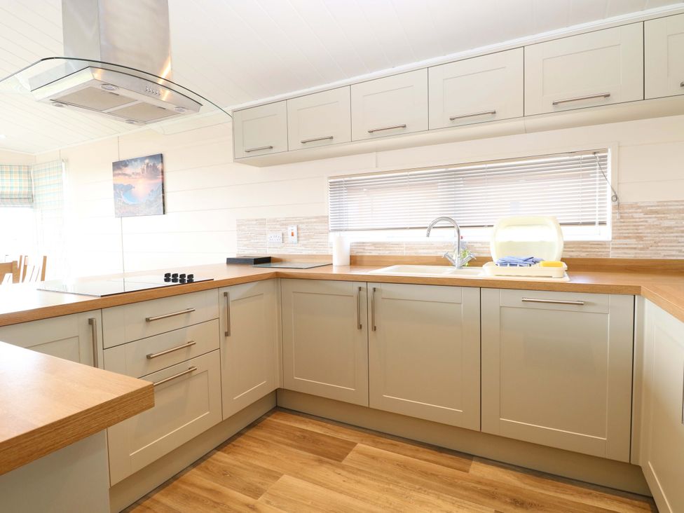 A kitchen with a sink and stove at Oak Tree Holiday Lodge in Stonham Aspal