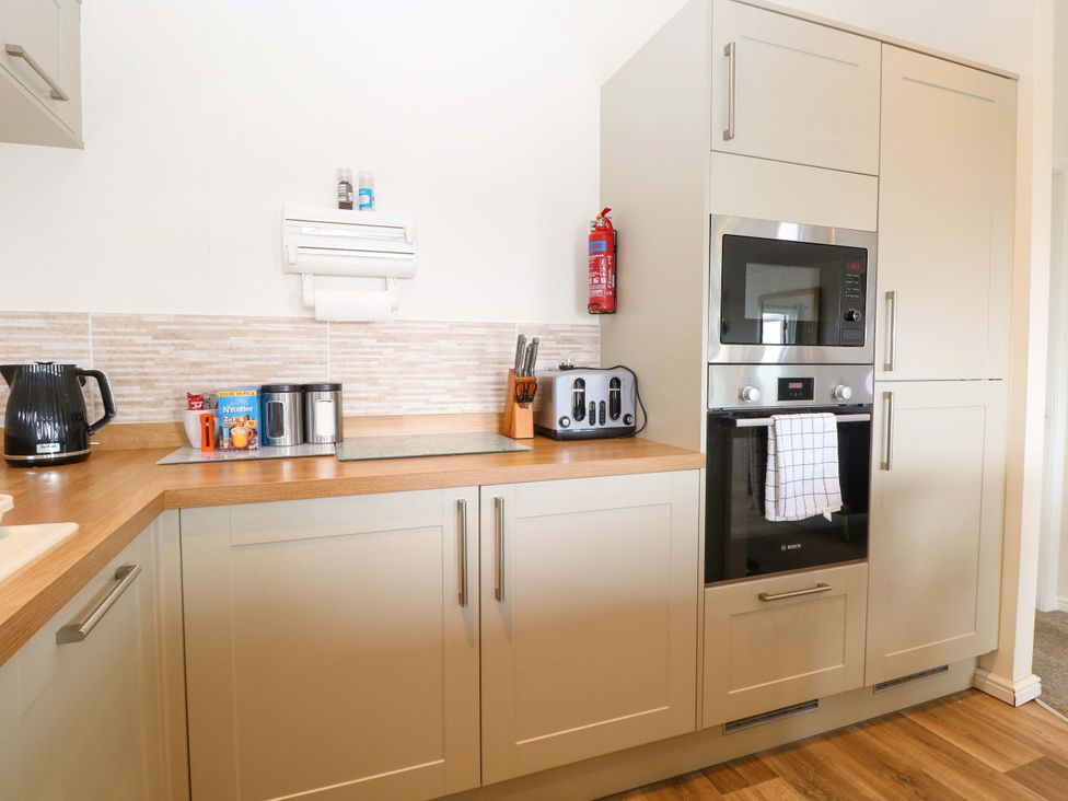 A kitchen with appliances and utensils at Oak Tree Holiday Lodge in Stonham Aspal