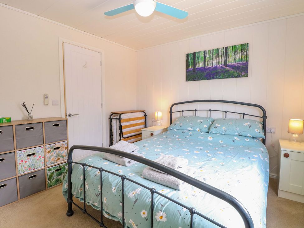 A bedroom with a bed and bedside tables at Oak Tree Holiday Lodge in Stonham Aspal