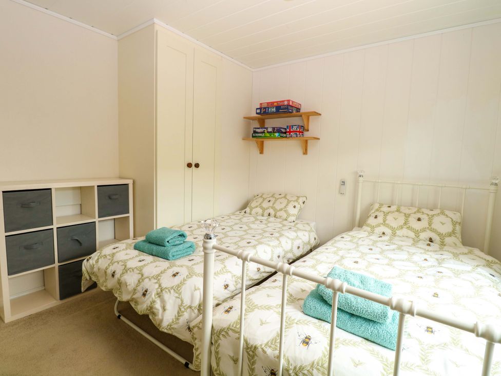 A bedroom with two beds and a storage unit at Oak Tree Holiday Lodge in Stonham Aspal