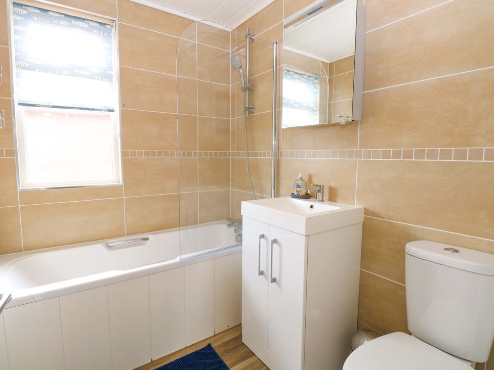 A bathroom with a bathtub, shower, sink, and toilet at Oak Tree Holiday Lodge in Stonham Aspal