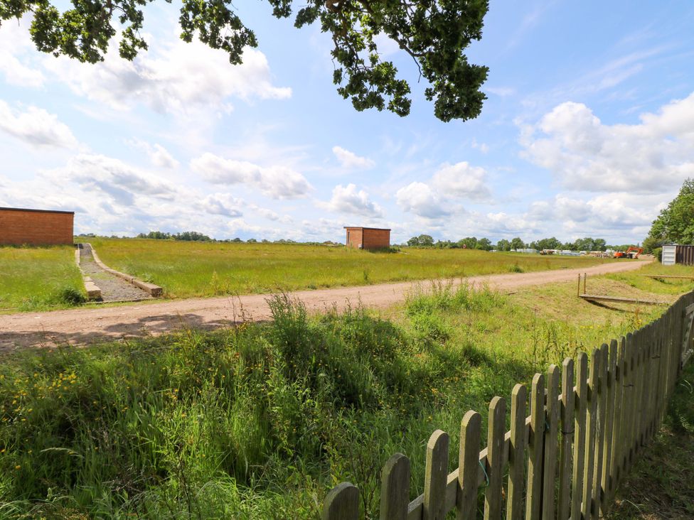 An outdoor scene with grass and a dirt path at Oak Tree Holiday Lodge in Stonham Aspal